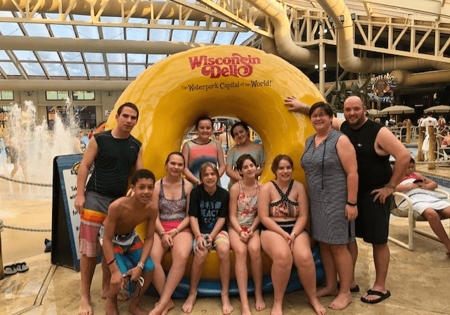 A group of people posing in front of an inflatable donut.