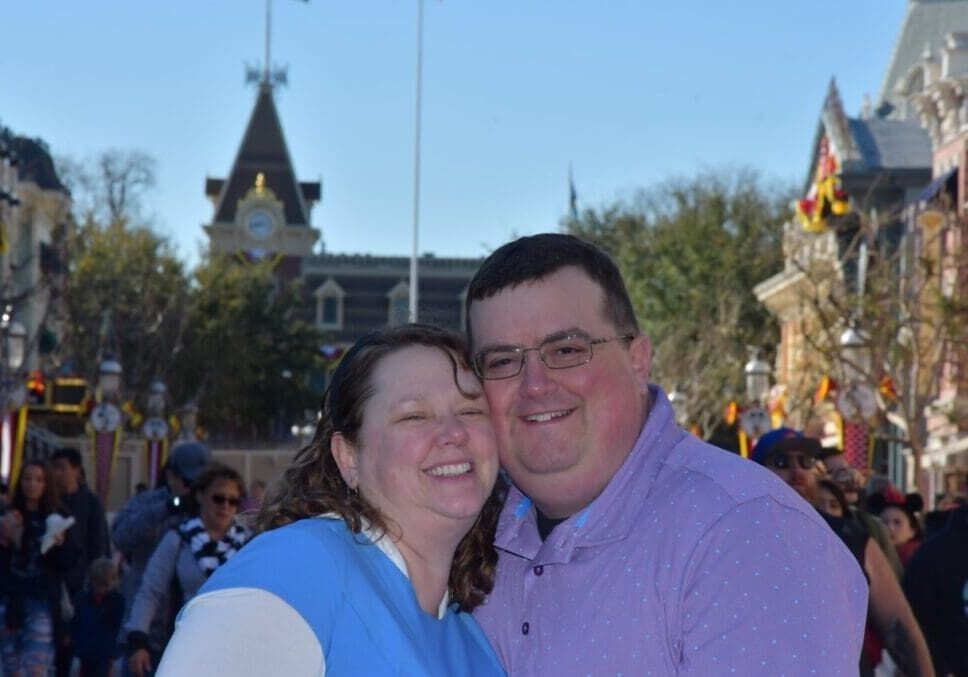 A man and woman posing for a picture in front of a crowd.