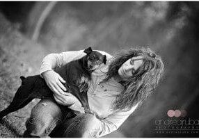 A black and white photo of a woman holding a dog.