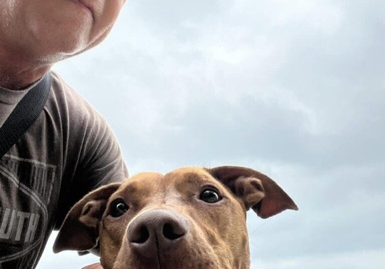 A man with a dog on a leash.