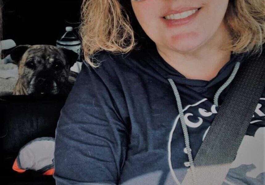 A woman in sunglasses sitting in the back seat of a car.