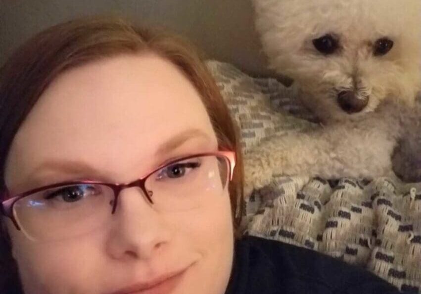 A woman with glasses and a white poodle.